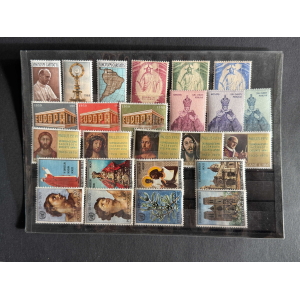 Sheet of colorful Vatican postage stamps arranged in a page, featuring religious figures, buildings, and pope portraits from mid-20th century, mounted on black background.