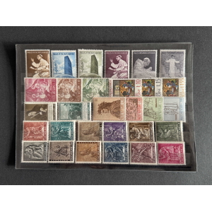 Display sheet of Vatican postage stamps in a grid, varied colors and designs, mounted in a protective case.