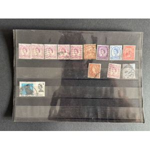 Page from a stamp collection showing vintage British stamps mounted on a black album page.