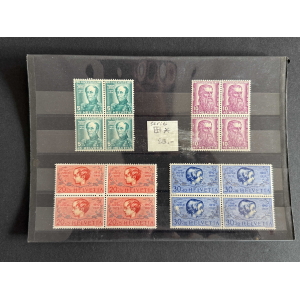 Sheet of Swiss postage stamps on a black album page: blocks of green 5 Helvetia stamps, purple 10s with bearded portrait, red 20s, and blue 30s, arranged in groups with a small note in the center.