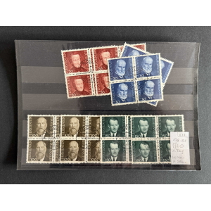 Block of vintage stamps in red, blue, brown, and green on a dark display sheet.