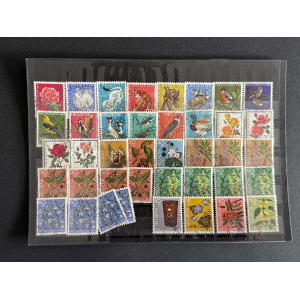Sheet of colorful Swiss Pro Juventute postage stamps featuring birds, flowers, and plants arranged in rows on dark background.