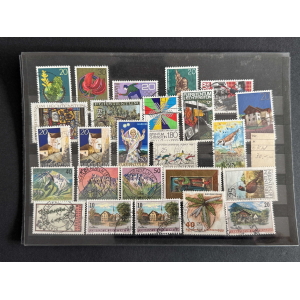 Collection of colorful Liechtenstein postage stamps on a binder page, showing flowers, buildings, and symbols.