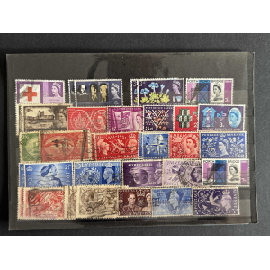 Assorted vintage postage stamps arranged on a dark display sheet, showing various designs and colors from different eras.