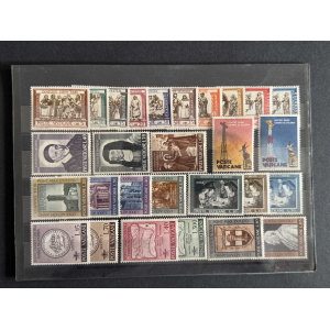 Sheet of vintage Vatican postage stamps mounted on a black page, featuring portraits, religious scenes, and architectural designs in multiple colors and denominations.
