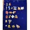 BM_1580_fjpg - globalcollection.ch globalcollection.ch - Blue binder page covered with a collection of colorful enamel pins, featuring various brand logos and souvenir icons arranged in rows.