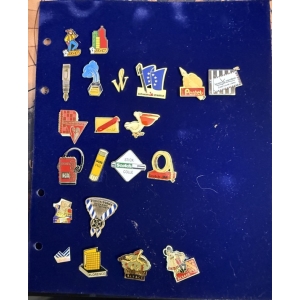 BM_1580_fjpg Blue binder page covered with a collection of colorful enamel pins, featuring various brand logos and souvenir icons arranged in rows.